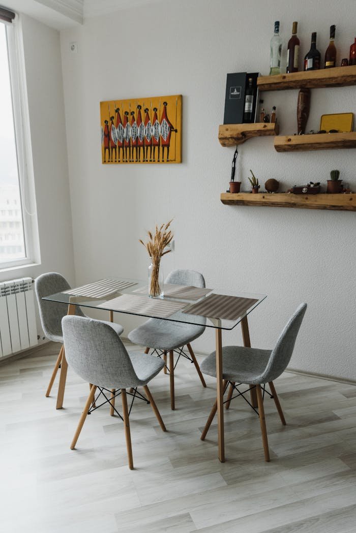 Cozy dining space featuring a modern table, chairs, and mounted shelves with decor.
