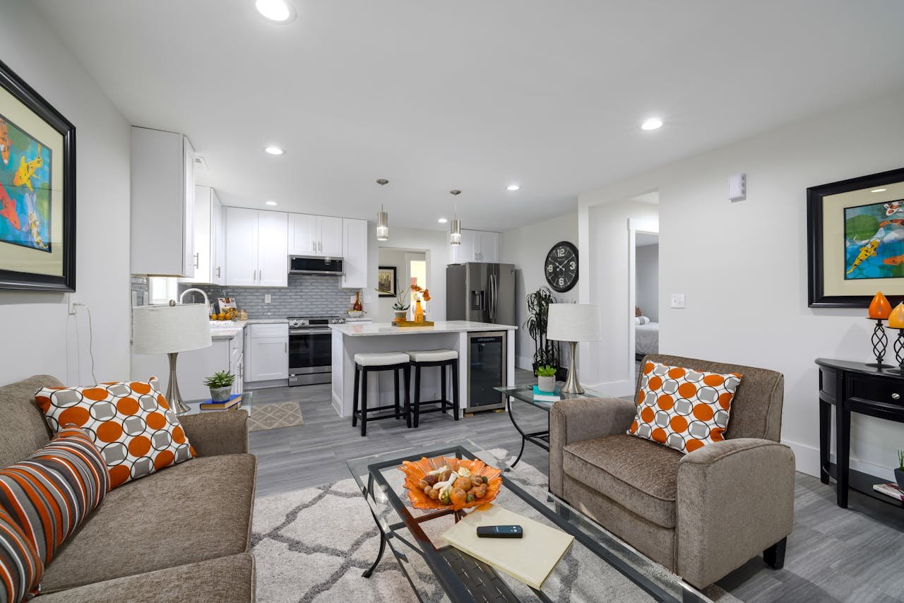 Stylish living room with an open kitchen, featuring modern décor and cozy ambiance.